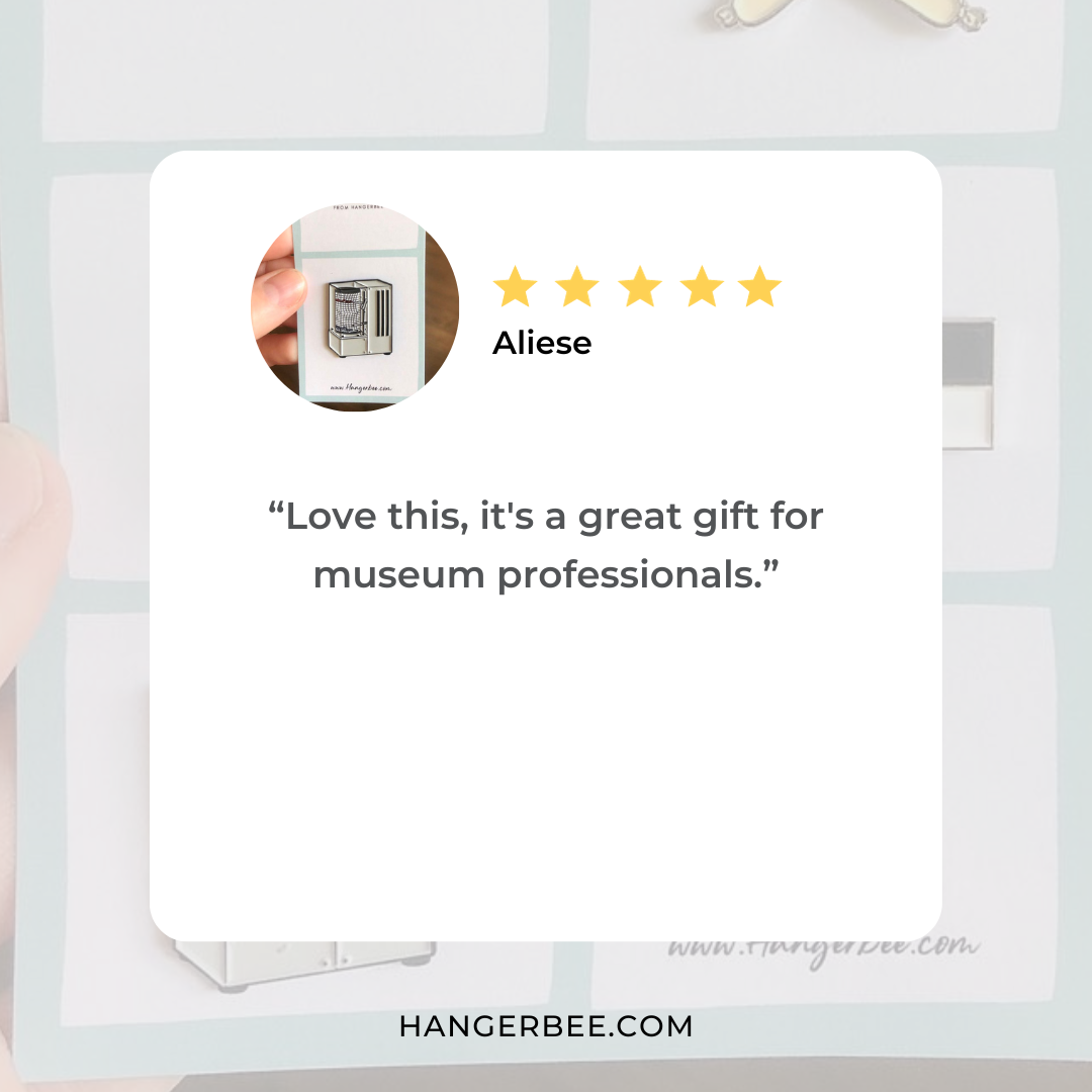 Positive review of Hangerbee padded hanger's Collections Toolbox Lapel Pin of a hygrothermograph pin on a card that's designed to look like an acid-free box lined with ethafoam. The card is on a small, cotton bag which is on a wood table.