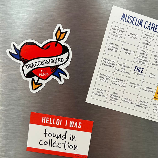Hangerbee padded clothing hangers has developed magnets, stickers, keychains, pins, and more, with museum collections professionals in mind. This image shows a Deaccessioned and Proud magnet and a Found in Collection magnet holding up a square Hangerbee business card on a refrigerator. 