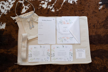 image featuring items in hangerbee padded hanger's save the dress, wedding dress preservation kit. The kit includes an heirloom safe, preservation quality padded clothes hanger, a large cotton garment bag, a large, zippered, cotton accessory bag and two small cotton drawstring bags, yards of cotton twill take, a wedding memories memory card, and instructions.